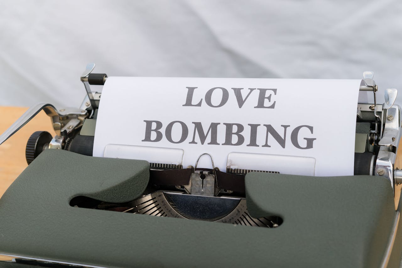 Close-up of a typewriter displaying the phrase 'Love Bombing' on paper.