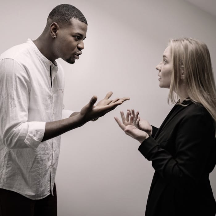 Woman trying to communicate healthy relationship boundaries to her husband while he reacts defensively, showing the challenges of setting boundaries in a marriage