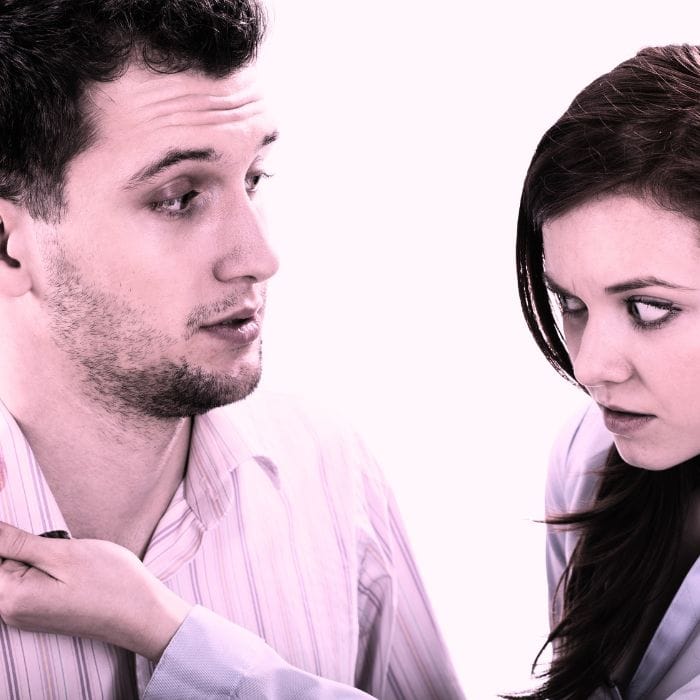 How To Know If My Husband Is Cheating: 15 Signs That Can’t Be Ignored 3 Woman discovering red lipstick on her husband's shirt collar when he comes home from work, a classic sign of a cheating husband