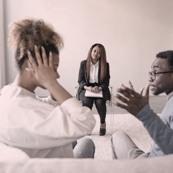 Emotional Cheating: 7 Painful Truths About Its Destruction 4 A couple sitting with a therapist during a counseling session to heal and rebuild trust after emotional cheating in their relationship.