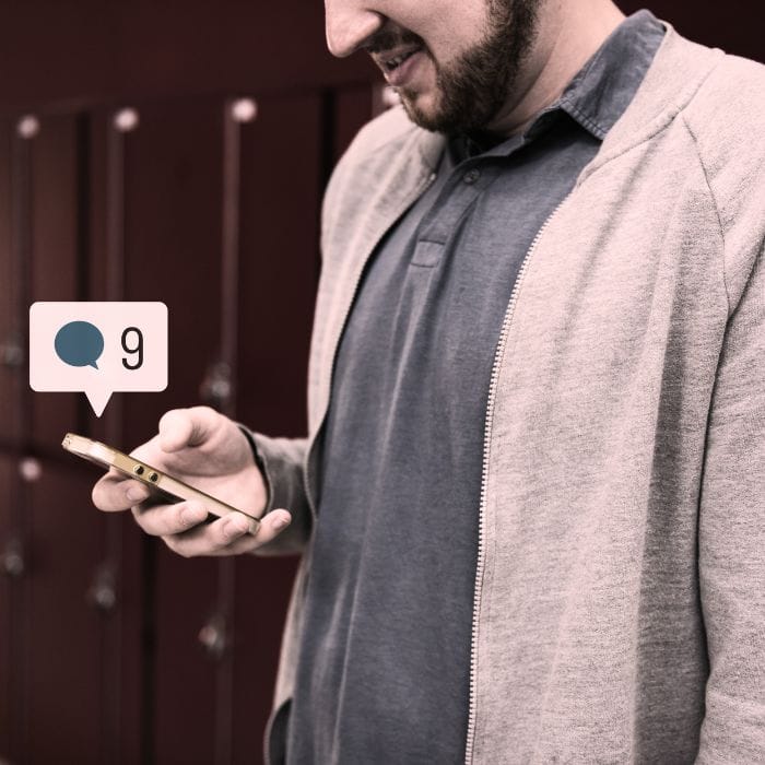 A man on his phone engaging in flirtatious social media interactions with women