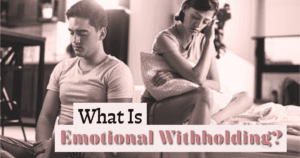 Couple sitting on a sofa with emotional distance between them, illustrating emotional withholding in a relationship.