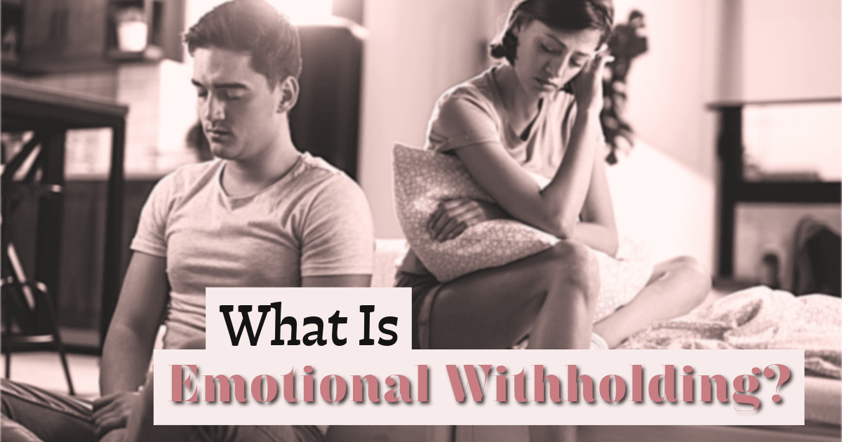 Couple sitting on a sofa with emotional distance between them, illustrating emotional withholding in a relationship.